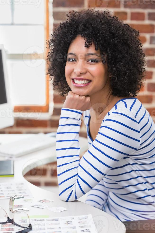lächelnder weiblicher Bildbearbeiter, der Computer im Büro benutzt foto