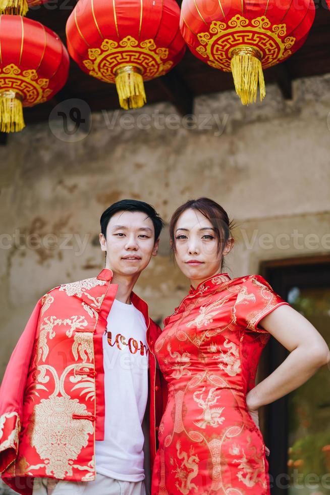 glückliches junges asiatisches paar in chinesischen traditionellen kleidern foto