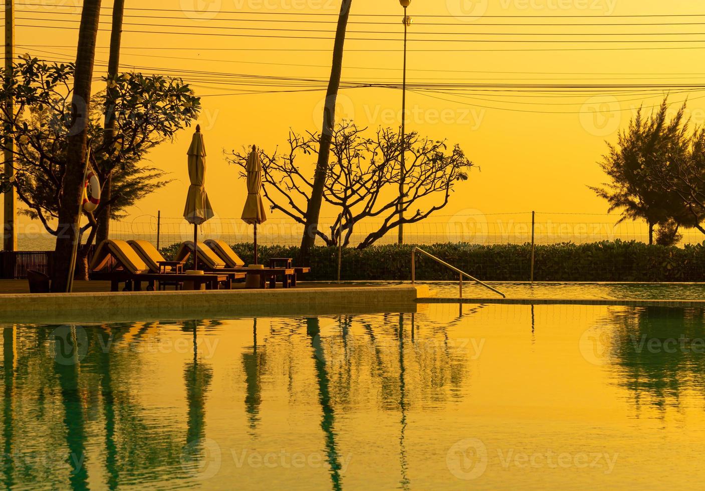 Sonnenschirm mit Bettpool um den Pool mit Ozean-Meer-Hintergrund foto