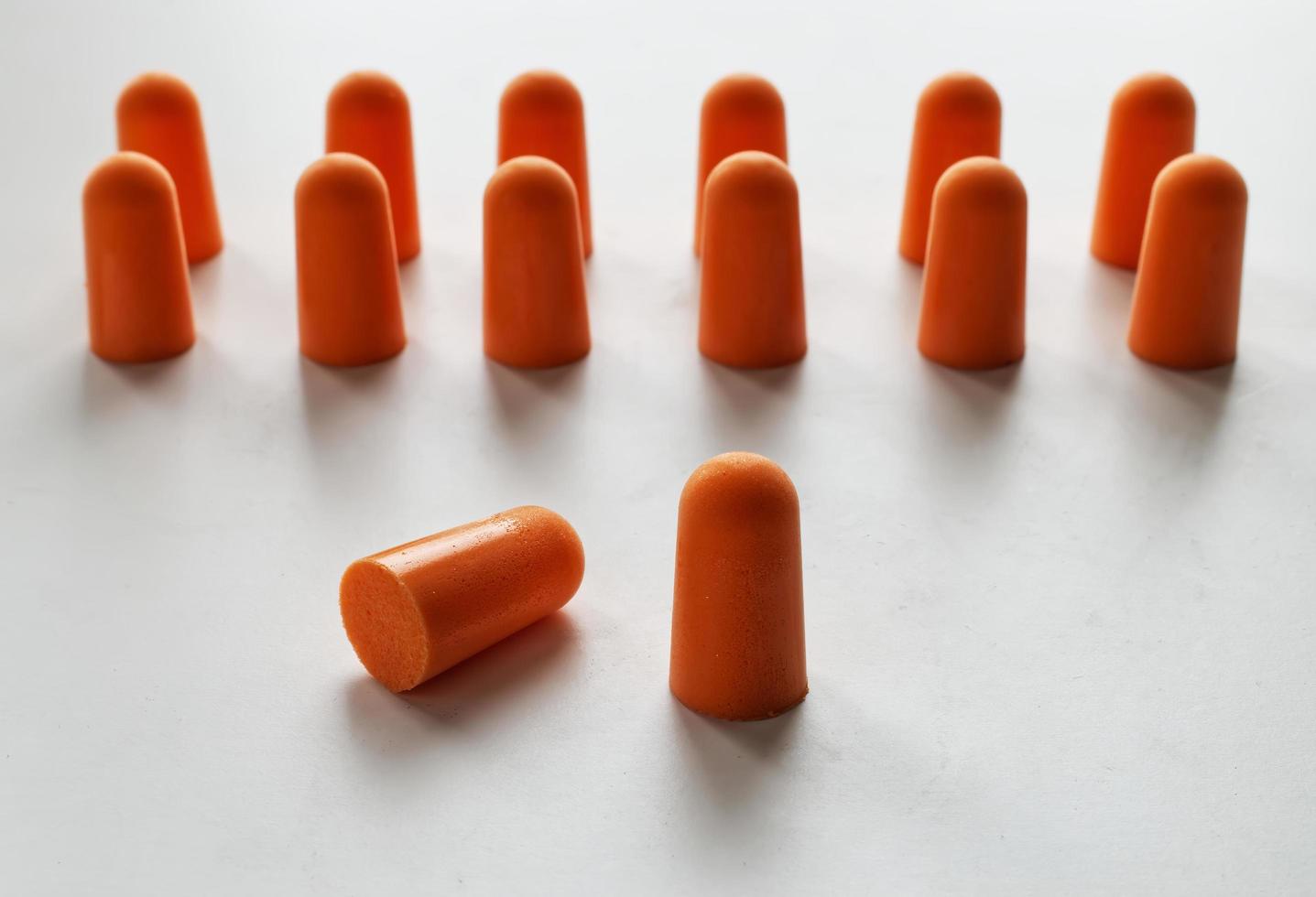 Orange Schaumstoff-Ohrstöpsel isoliert auf weißem Hintergrund foto