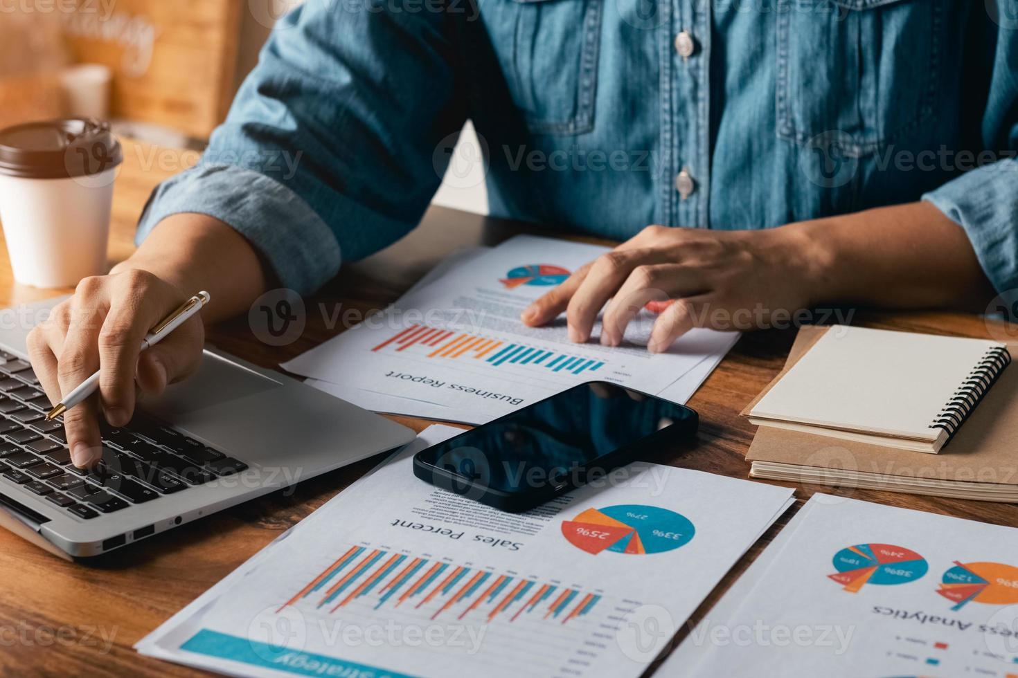 Buchhaltungskonzept. geschäftsmann, der mit einem laptop arbeitet, um finanzumsatzdaten und diagrammdiagramme zum wirtschaftswachstum zu analysieren. im Café. foto