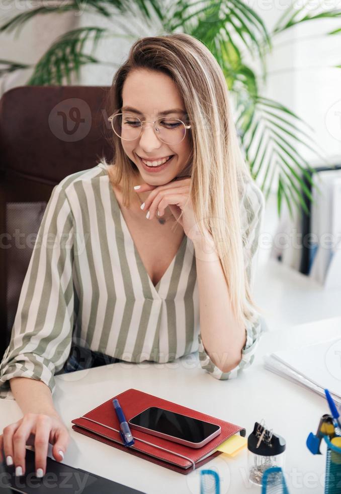 junge Frau, die an einem Computer arbeitet foto