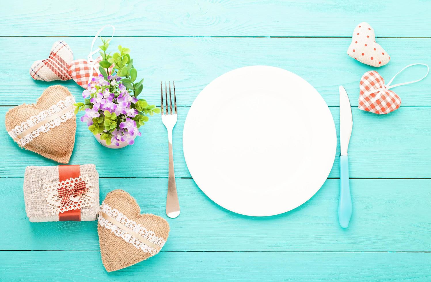 valentinstag-set mit silberbesteck. Valentinstag Liebe schön. romantisches abendessen, geschirr und herzen auf hölzernem hintergrund. draufsicht. foto