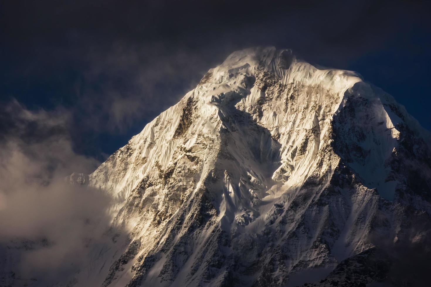 der sonnendurchflutete, schneebedeckte gipfel von annapurna süden auf dem annapurna base camp trail im nepal himalaya. foto