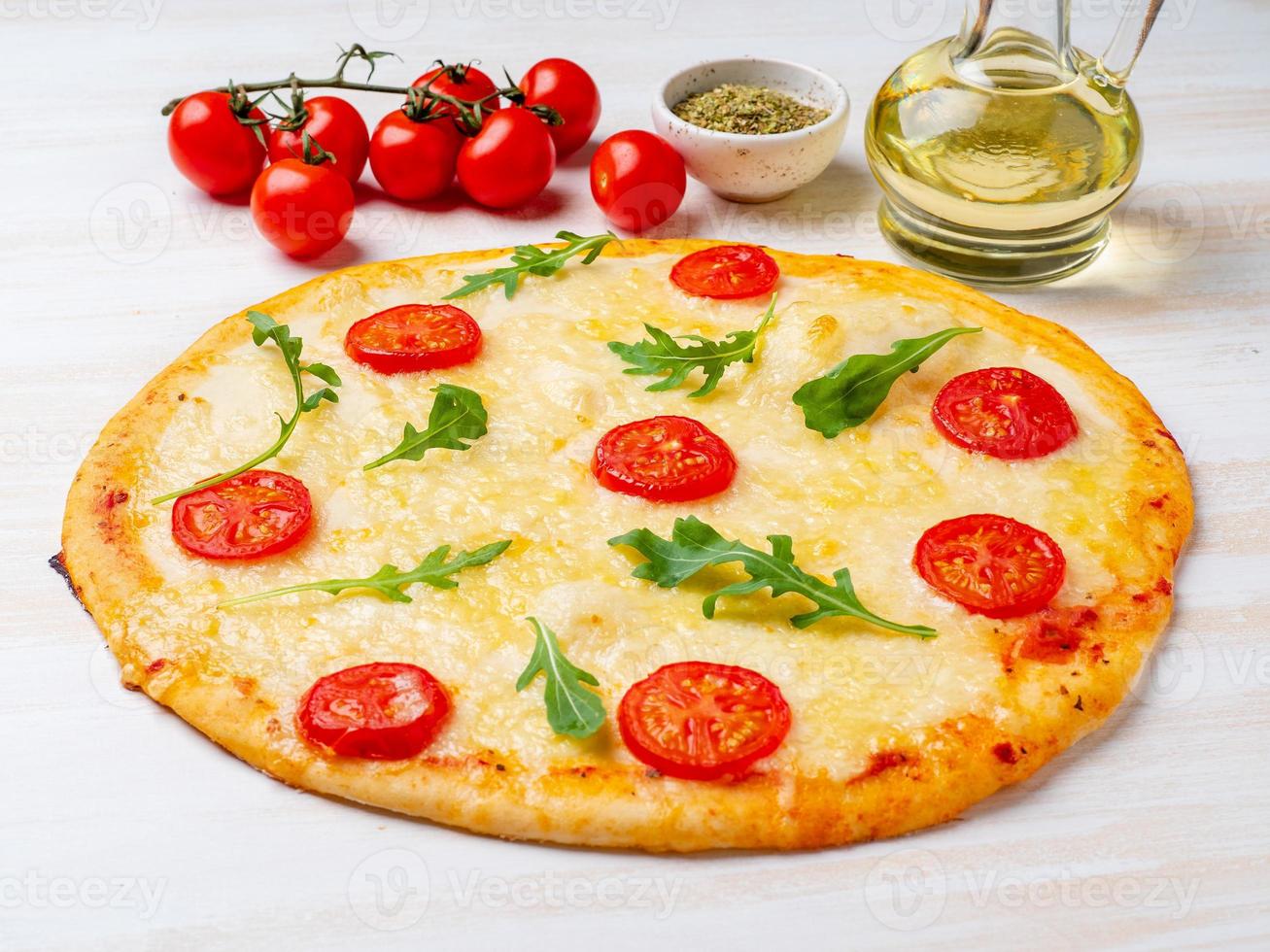 heiße hausgemachte italienische Pizza Margherita mit Mozzarella und Tomaten foto