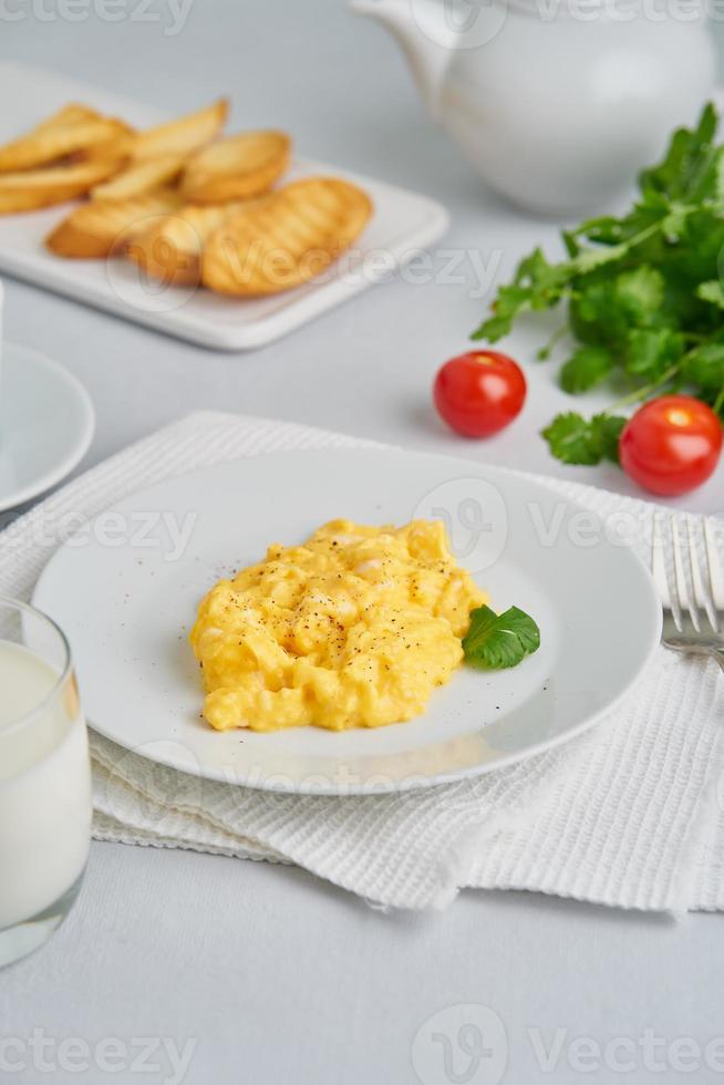 Rührei, Omelett. frühstück mit gebratenen eiern, glas milch, tomaten foto