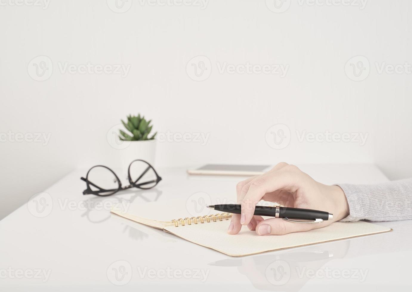 frau, die auf notizbuchseite, büroarbeit oder studienkonzept schreibt foto