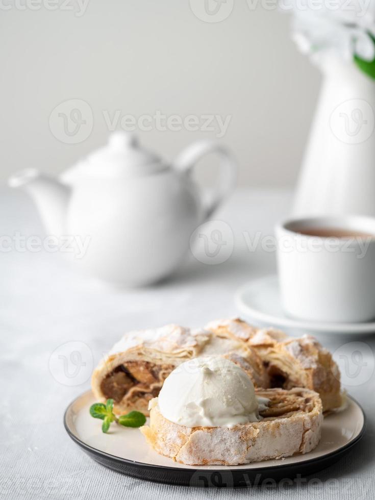 Apfelstrudel mit Eis und Zimt. gebackener Kuchen und Tee, leckeres Dessert foto