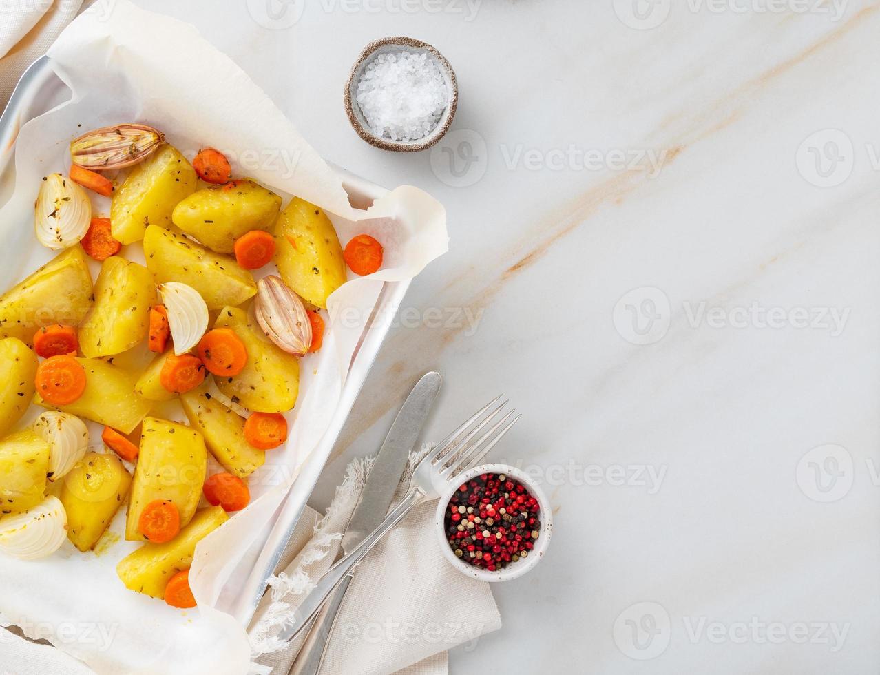 Buntes gebratenes Gemüse auf Tablett mit Pergament. Kartoffeln, Karotten und Zwiebeln. foto