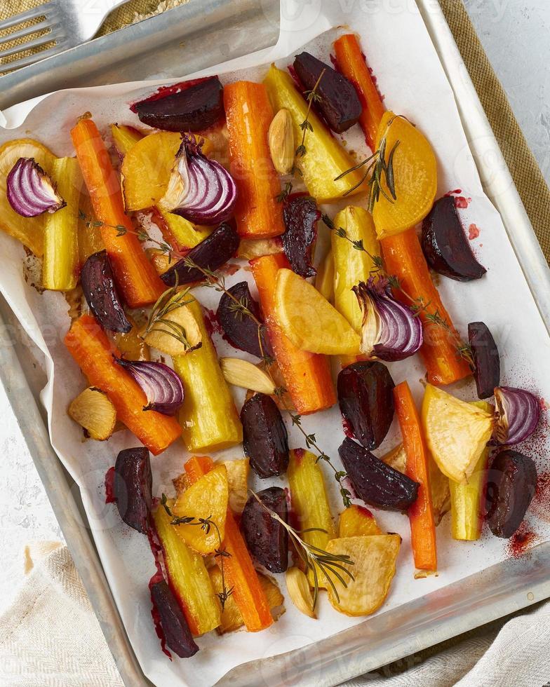 Buntes gebratenes Gemüse auf Tablett mit Pergament. Mischung aus Karotten, Rüben, Rüben foto