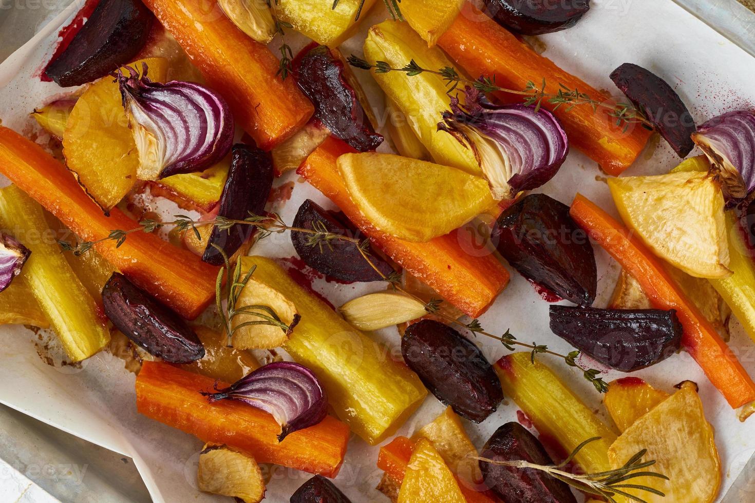 Buntes gebratenes Gemüse auf Tablett mit Pergament. Mischung aus Karotten, Rüben, Rüben foto