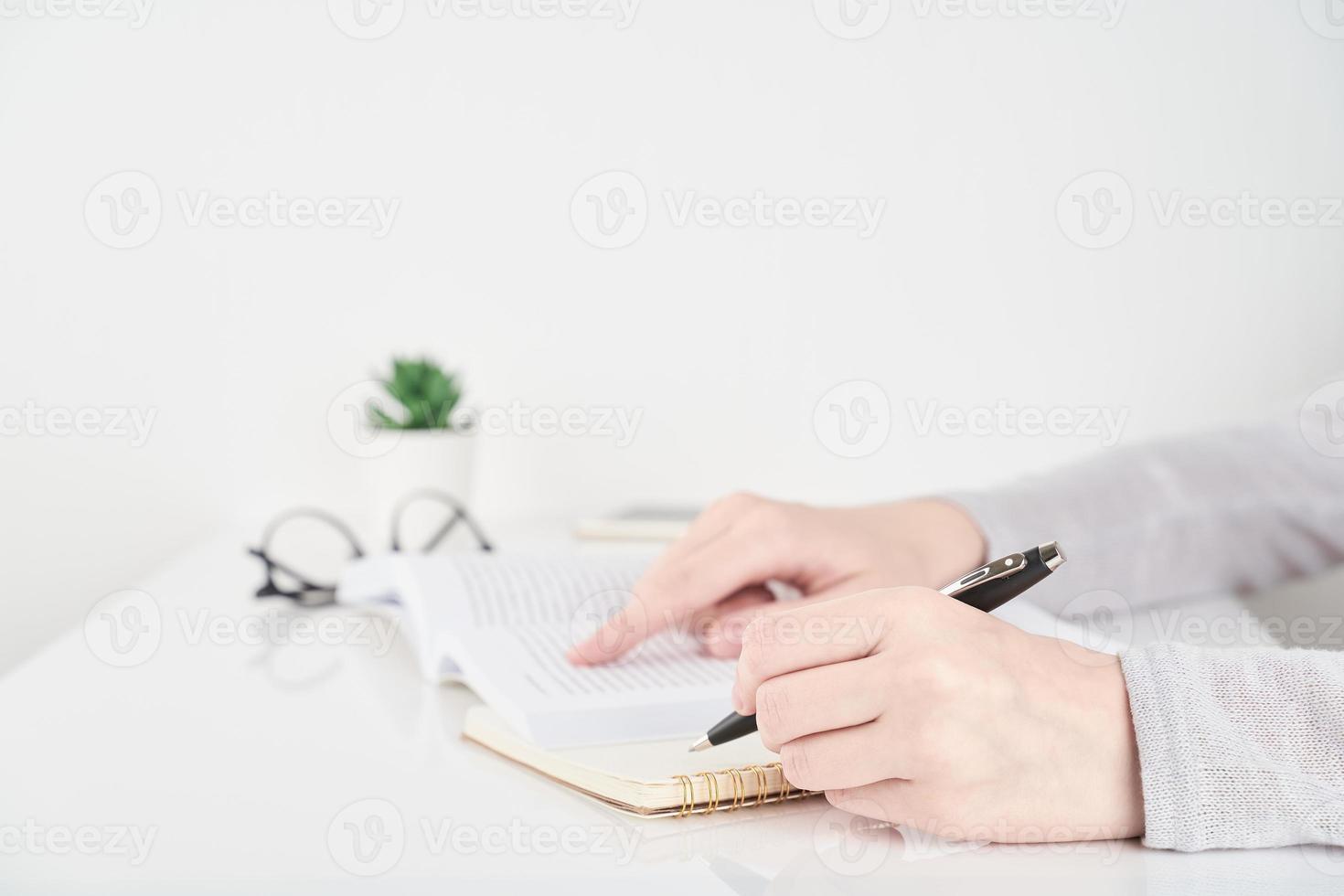 frau, die informationen im buch, büroarbeitskonzept auf weißem wandhintergrund sucht foto