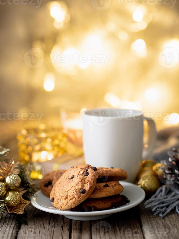 gemütlicher abend, tasse getränk, weihnachtsschmuck, kerzen und lichtergirlanden foto