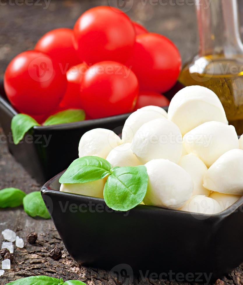 frischer Salat mit Kirschtomaten, Basilikum, Mozzarella und schwarzen Oliven. foto