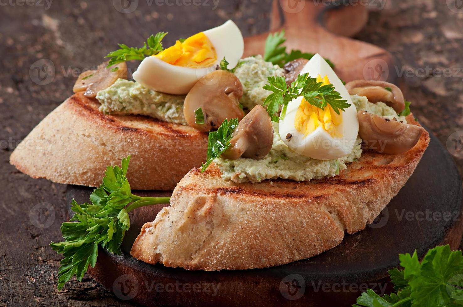 Bruschetta mit einer Paste aus grünen Erbsen, Pilzen und Ei foto