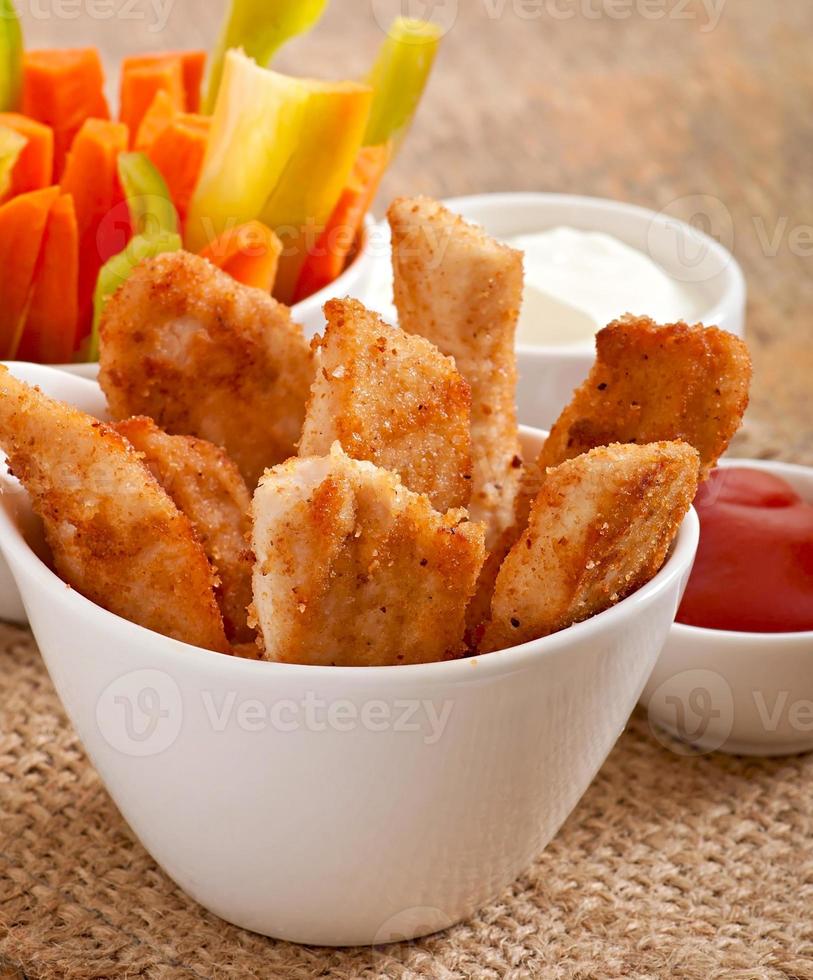 Chicken Nuggets mit Soße und Gemüse foto