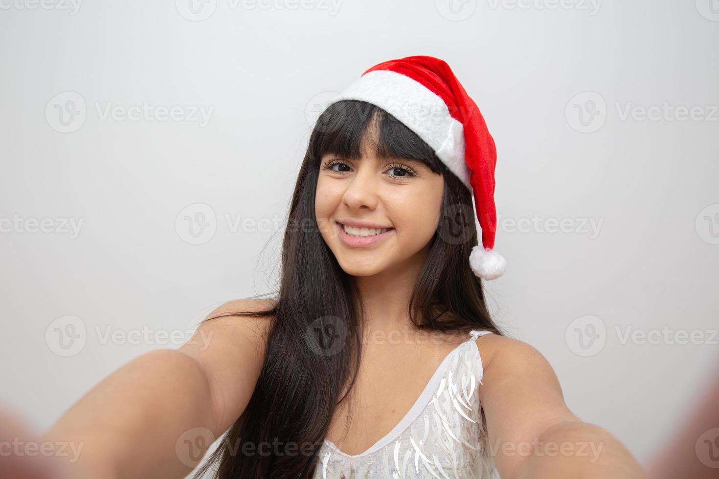 junge frau, die selfie mit weihnachtsmütze zieht foto