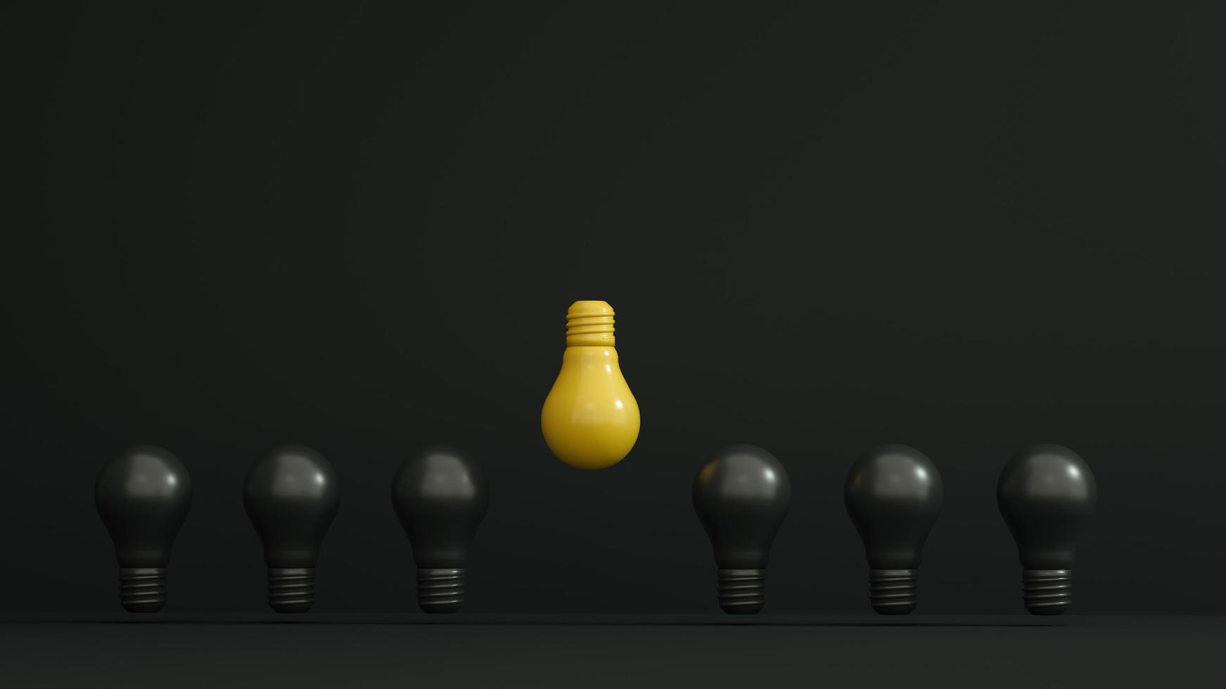 gelbe Glühbirne umgekehrt und höher unter schwarzen Glühbirnen auf dunklem Hintergrund. Führung, Innovation, Autorität, großartige Ideen und Individualitätskonzepte. foto