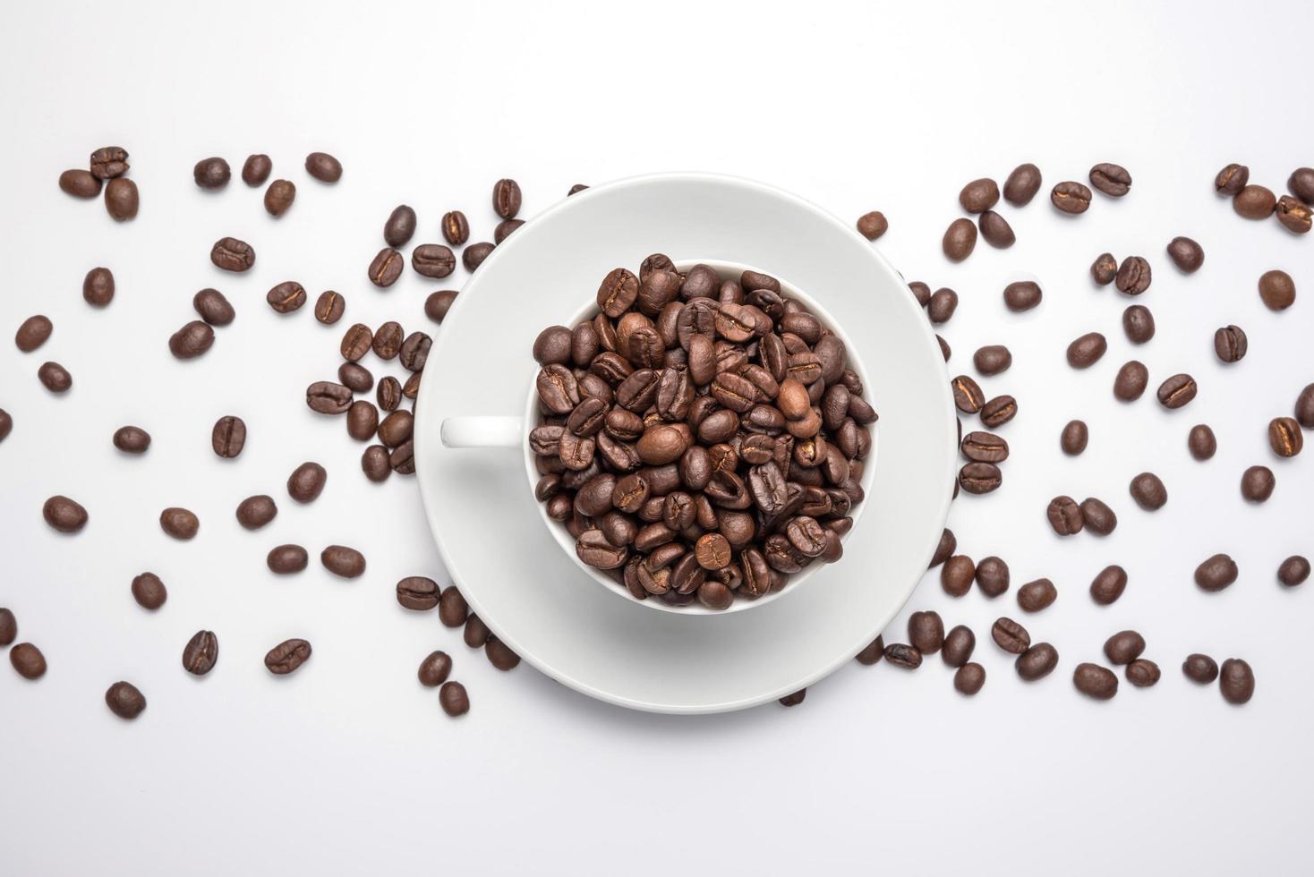 Tasse und Kaffeebohnen, isoliert auf weißem Hintergrund foto