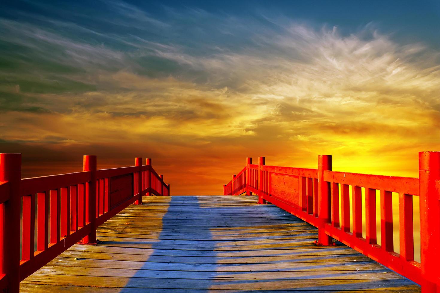 rote Holzbrücke mit dem goldenen Himmel. foto