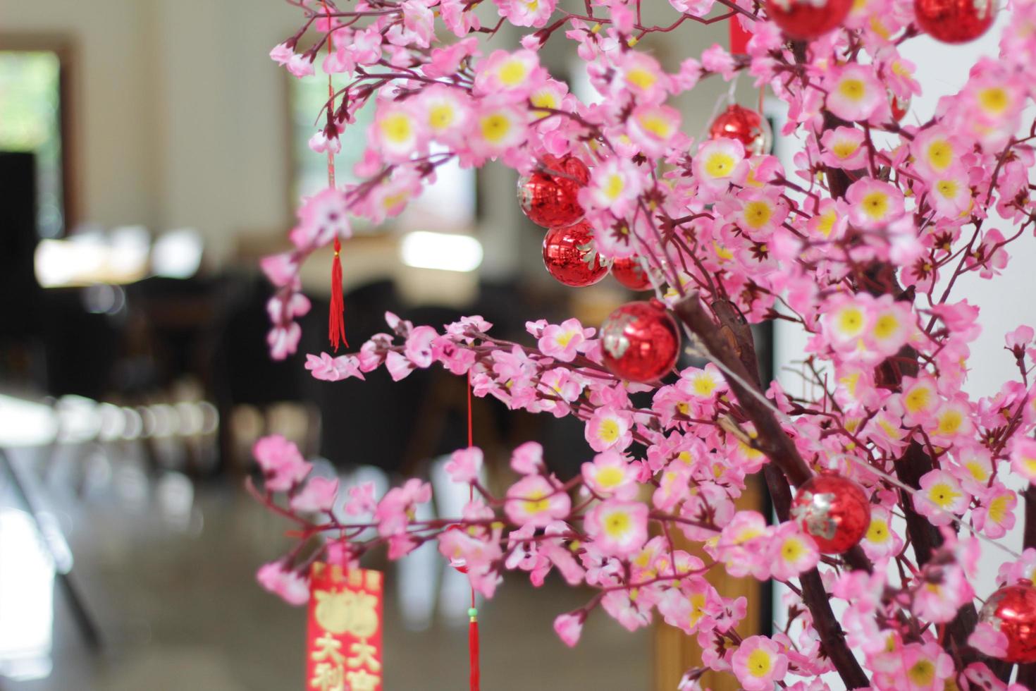 Rosa Kirschblüten mit chinesischen Ornamenten auf einem verschwommenen Café-Hintergrund foto