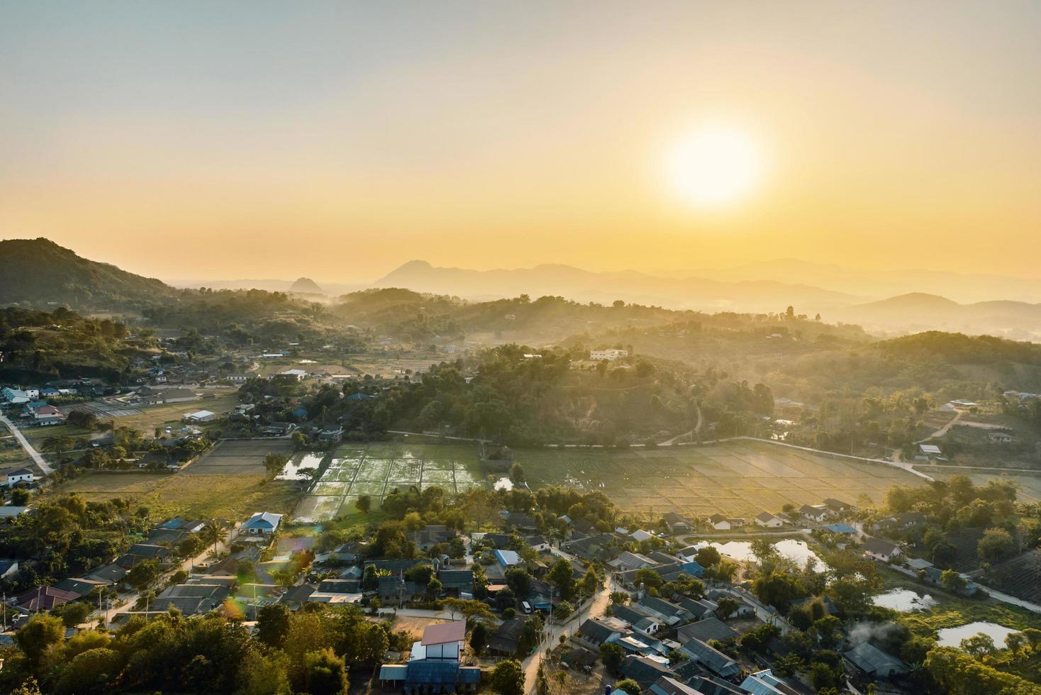 sonnenuntergang von landhäusern zwischen bewaldeten bergen im nördlichen ländlichen gebiet in thailand foto