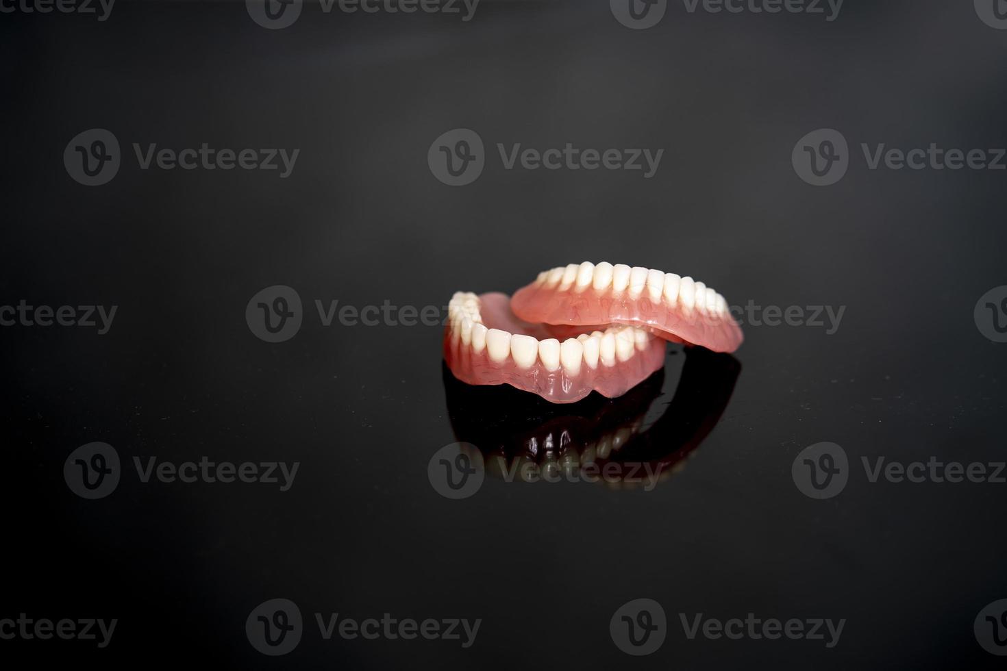 Anatomiemodell für menschliche Zähne und Kiefer zur medizinischen Illustration isoliert auf schwarzem Hintergrund mit Kopierplatz für Text. gesunder zahn, zahnpflege und kieferorthopädisches konzept. foto