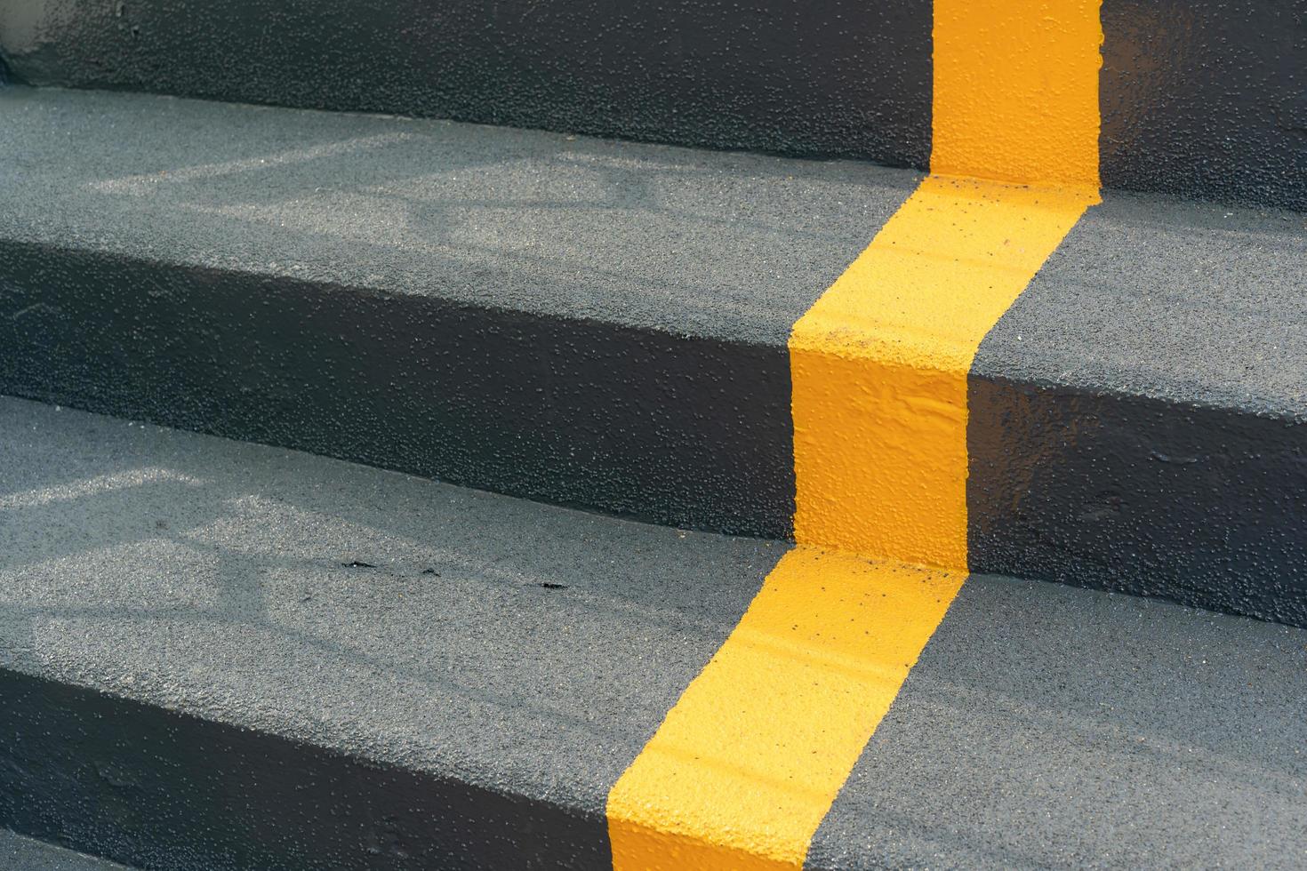 die Treppe der Überführung mit gelber Fahrbahnlinie und Geländer zur Sicherheit beim Überqueren der Straße. Wegzeichen auf der Leiter. gelbes kreuz auf der treppe. foto