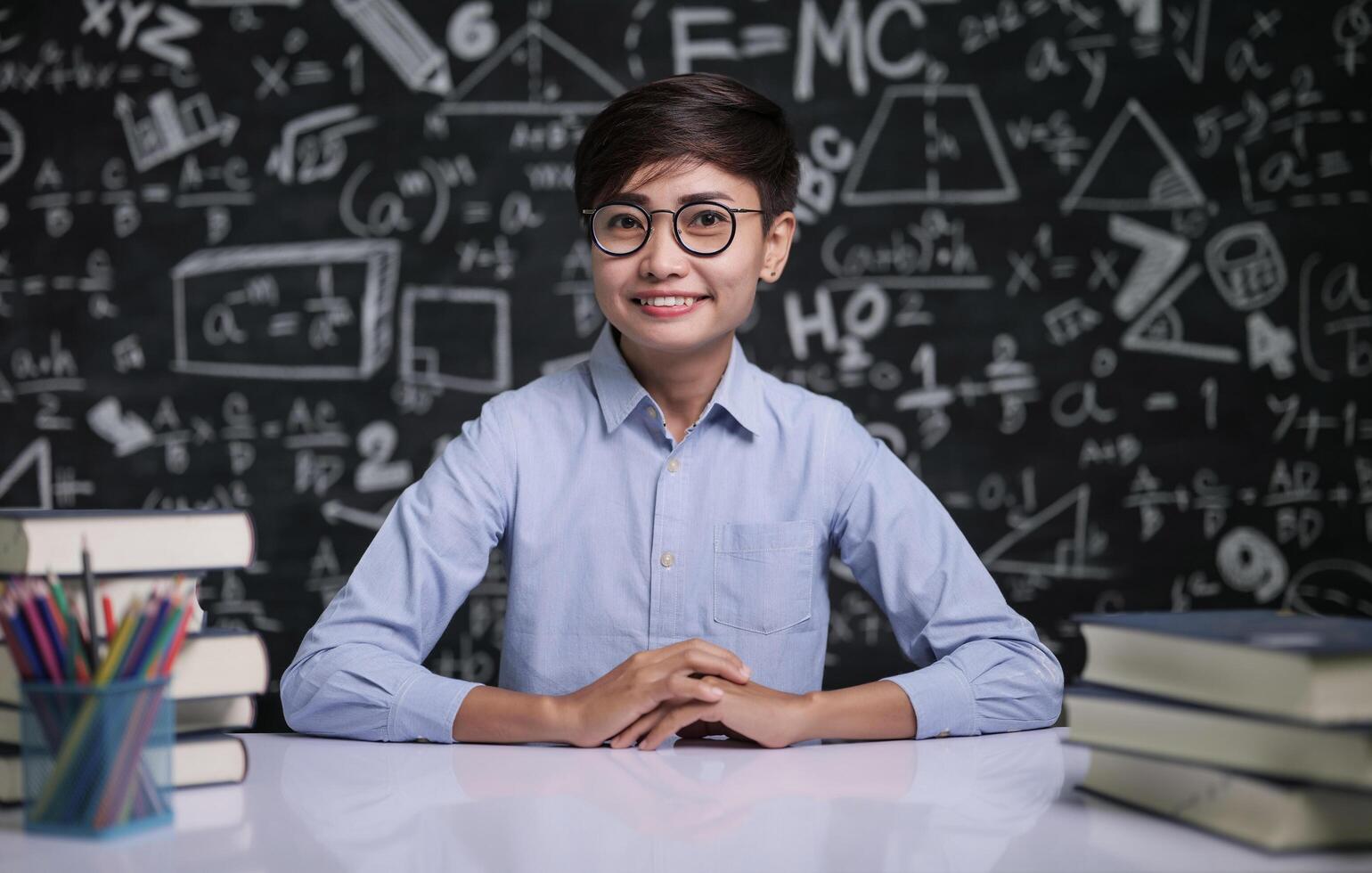 Der Lehrer saß am Tisch, um die Schüler im Klassenzimmer zu unterrichten foto