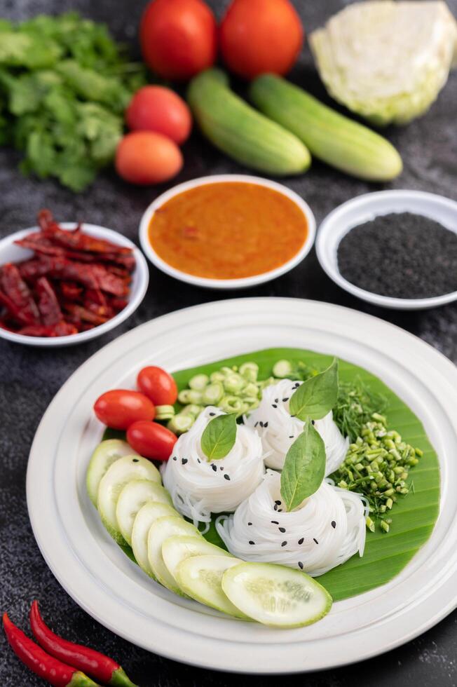 Nudeln im Bananenblatt mit schön angerichtetem Gemüse und Beilagen. Thai Essen. foto