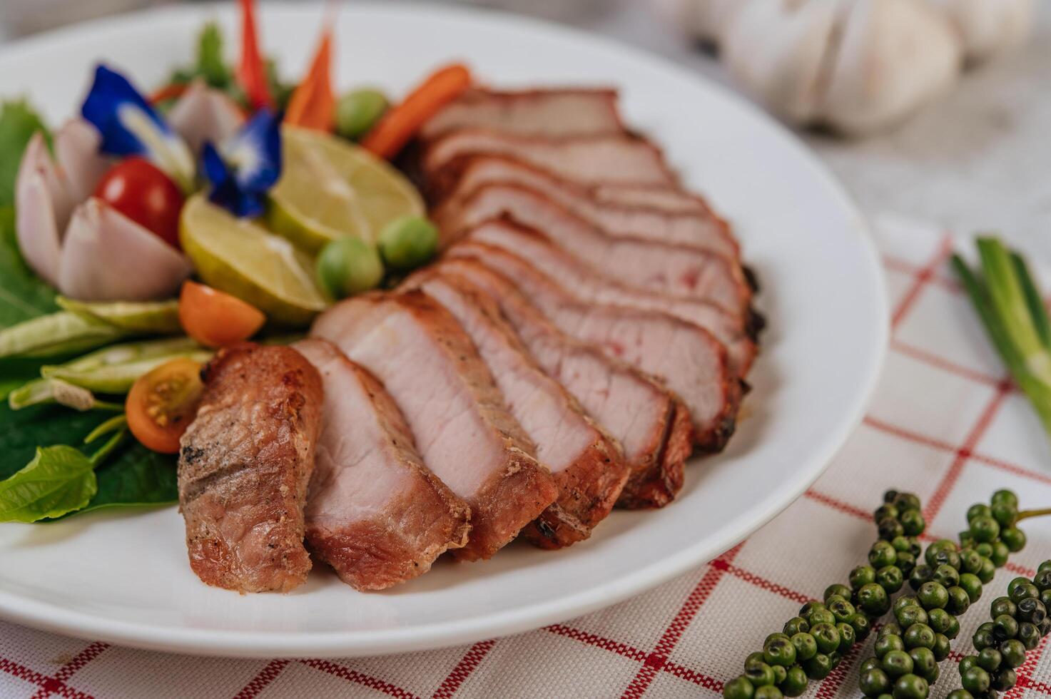 Schweinefleisch mit Zitrone, Zwiebel, roter Zwiebel, Tomate, langer Bohne, Schmetterlingserbsenblüte und Minze. foto