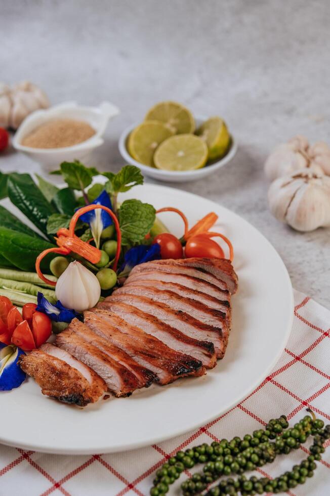 Schweinefleisch mit Zitrone, Zwiebel, roter Zwiebel, Tomate, langer Bohne, Schmetterlingserbsenblüte und Minze. foto