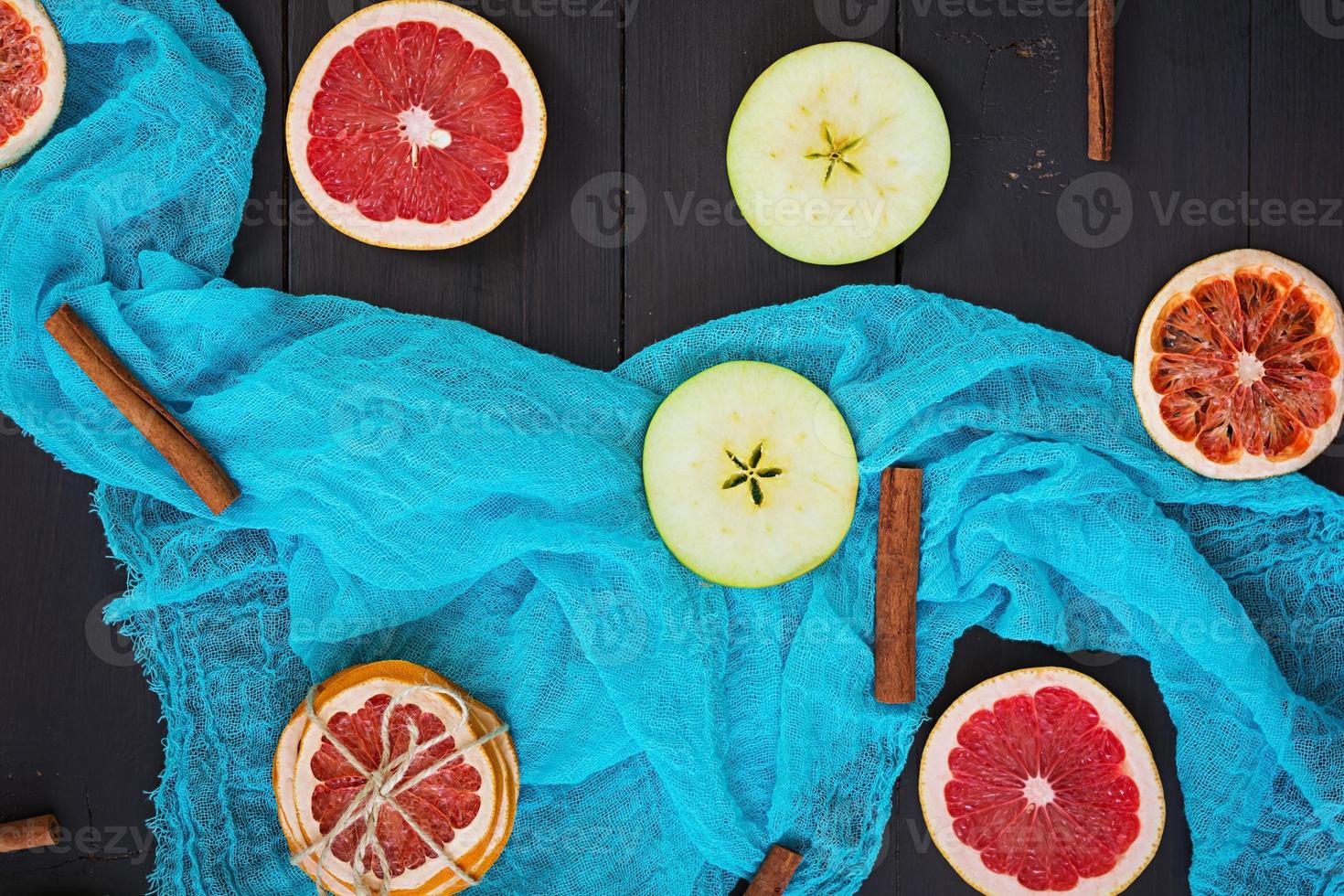 Apfel, Grapefruit und Zimt auf Holzhintergrund. Zutat für heißen Glühwein. Ansicht von oben foto