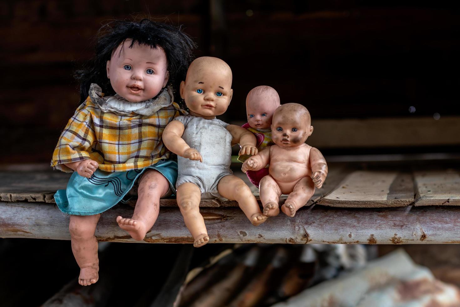 eine Gruppe von Babypuppen, die in einem alten Holzhaus sitzen. foto