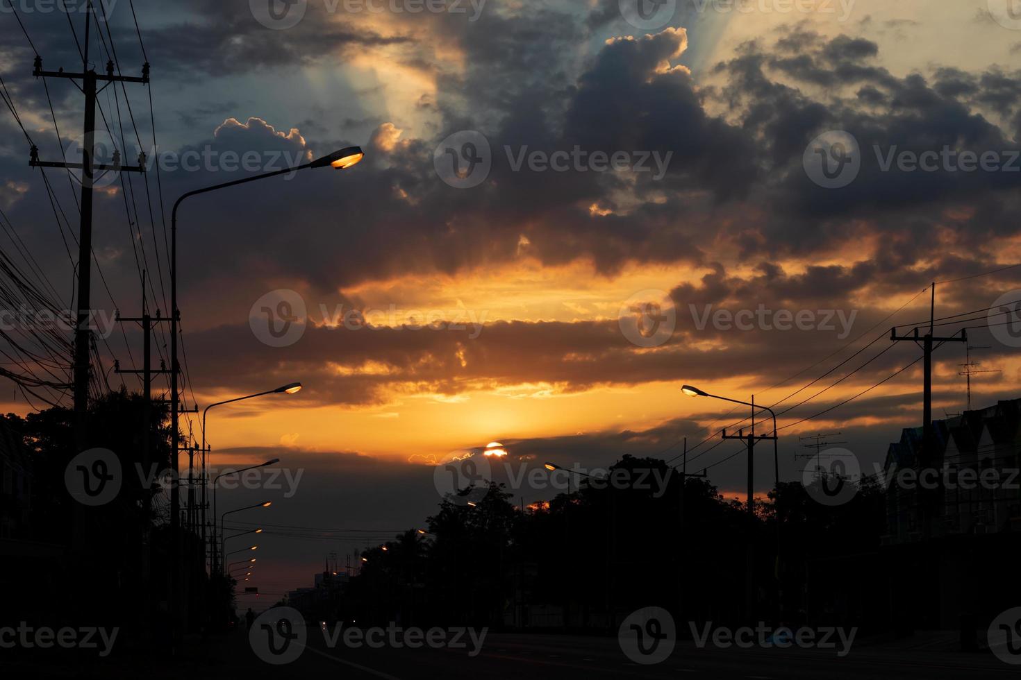 Bewölkter Sonnenaufgang über einer dunklen Straße. foto