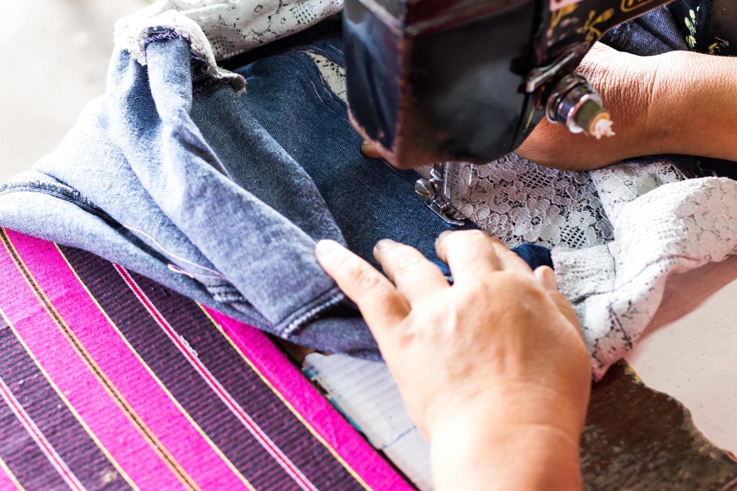 Repariere Jeans mit einer alten Nähmaschine. foto