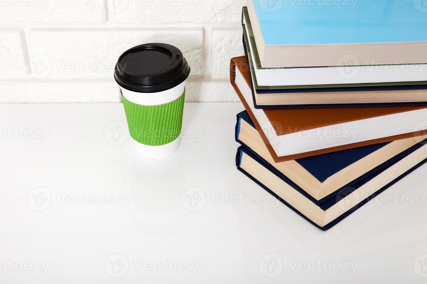 Bildungsliteratur. Tasse Kaffee und Bücher auf dem Tisch in einer Klasse. draufsicht und kopierraum. selektiver Fokus foto