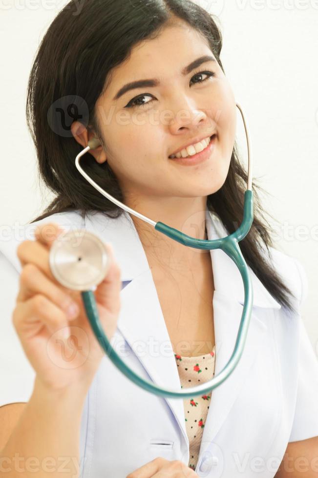 glückliche Ärztin, die Stethoskop heraushält foto