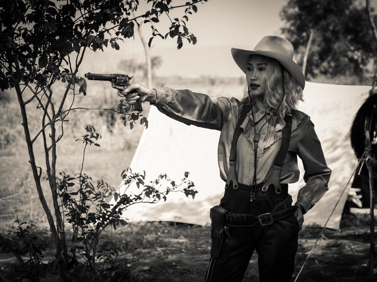 Ein junges Cowgirl steht mit einer Waffe, um die Sicherheit des Lagers im westlichen Bereich zu bewachen foto