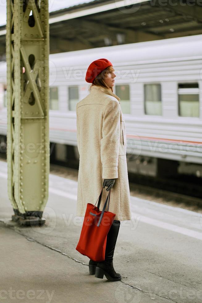 Bahnhof. schönes Mädchen wartet auf den Zug. Frau reist mit leichtem Gepäck. foto