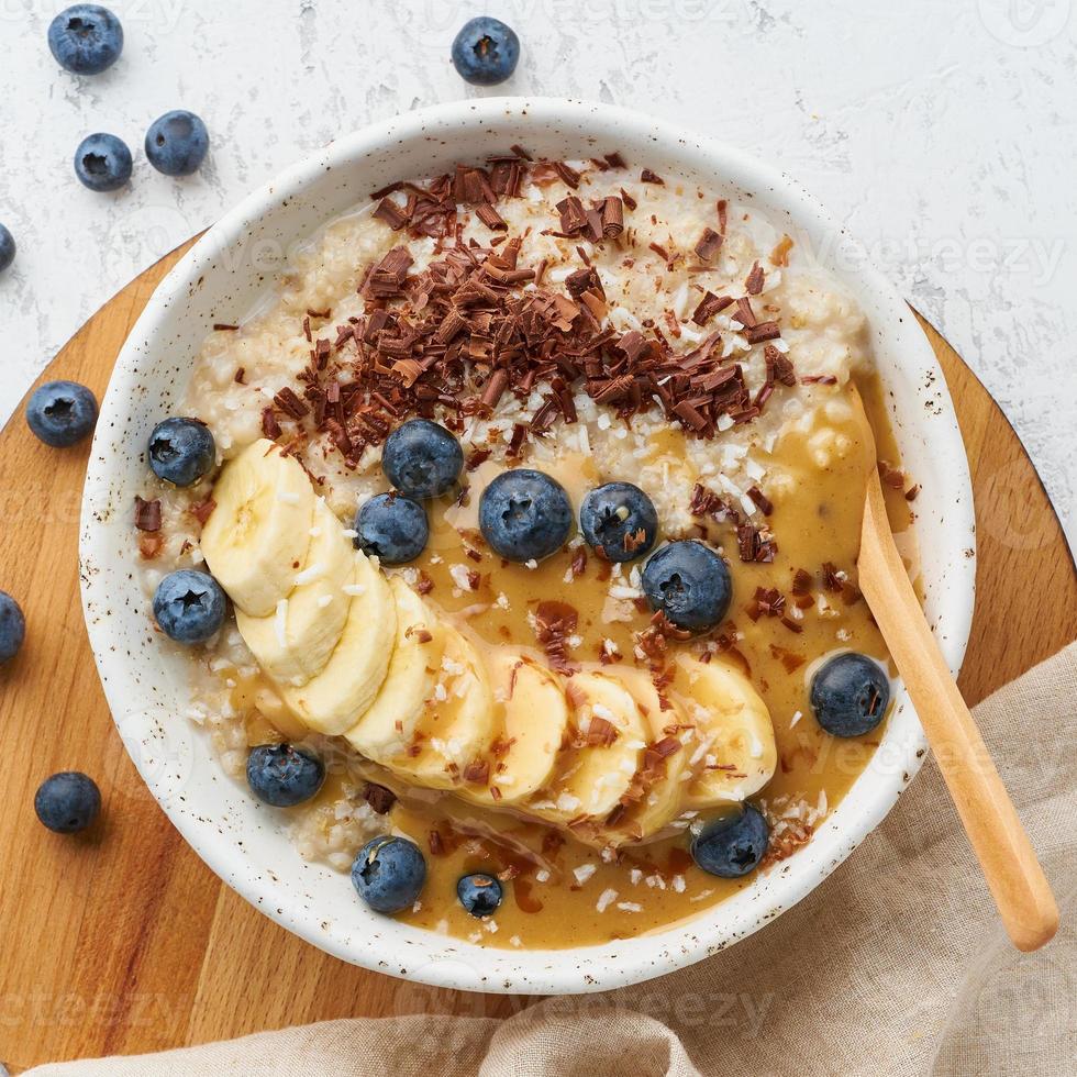 Hafermehl mit Beeren und Früchten, Strichdiät, auf Draufsicht des hölzernen weißen Hintergrundes foto