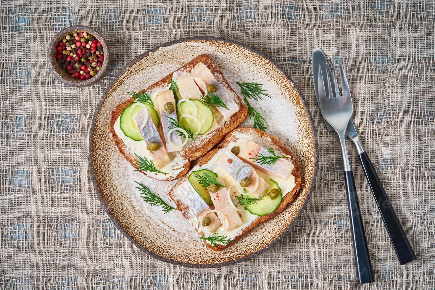 hering smorrebrod - traditionelle dänische sandwiches. Schwarzes Roggenbrot mit Hering auf grauer Serviette foto