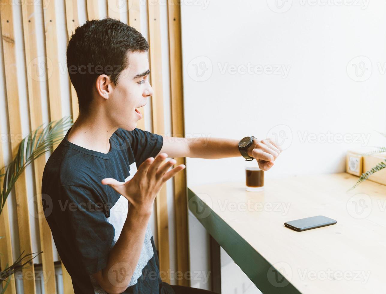 junger erwachsener schaut auf die uhr. Zeitmanagement-Konzept. gestresster kaukasischer mann mit schwarzen haaren, der angst hat, zu spät zu kommen, zeit verloren. Mädchen kommt zu spät zum Date foto