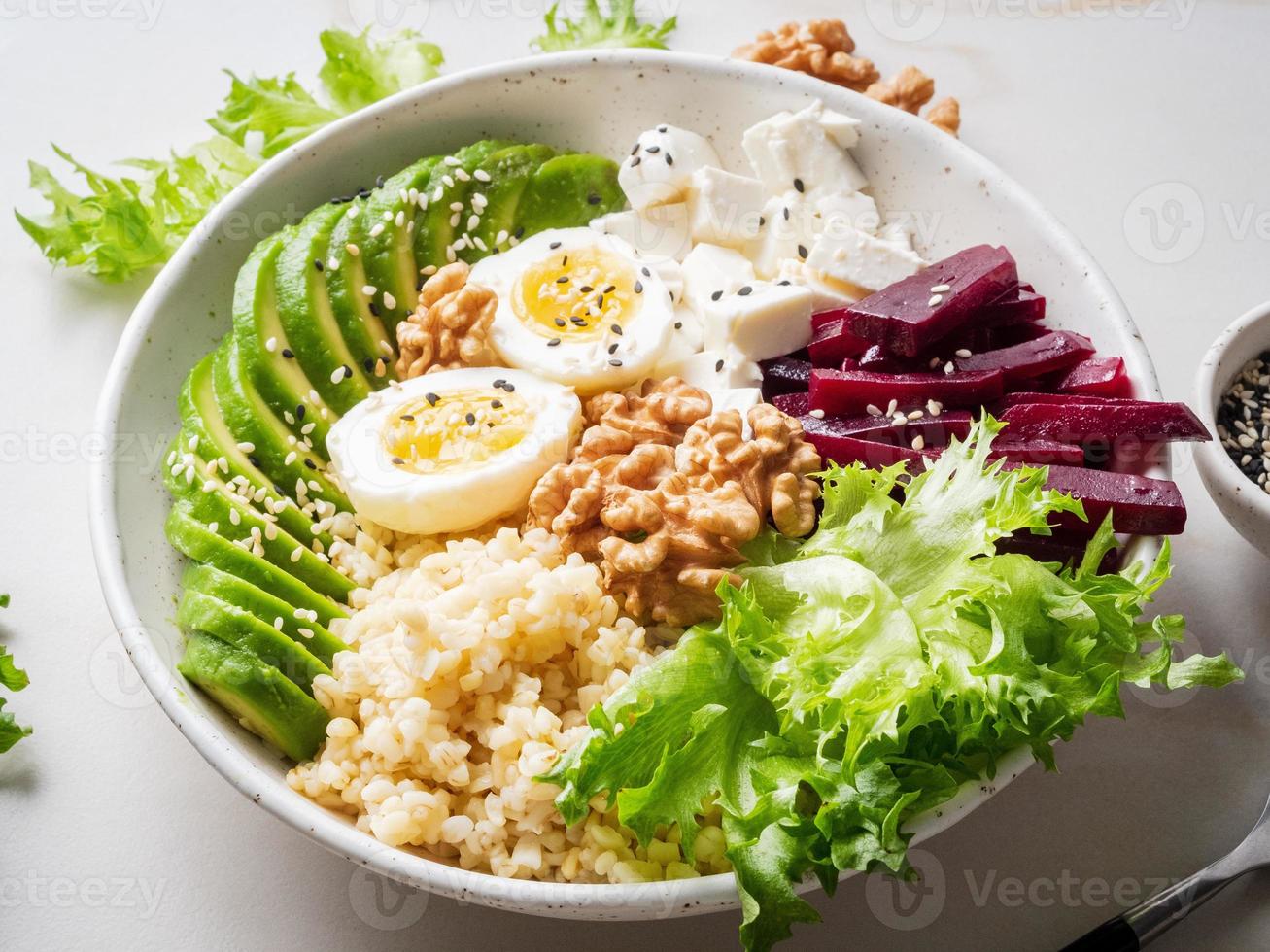 Buddha Bowl, ausgewogene Ernährung, vegetarisches Menü. Eier, Avocado, Salat, Bulgur foto