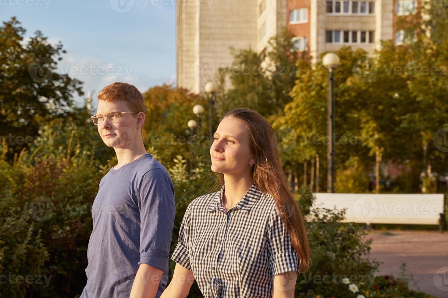 Jugendpaar, das im Park spazieren geht, Junge und Mädchen, die sich an den Händen halten foto