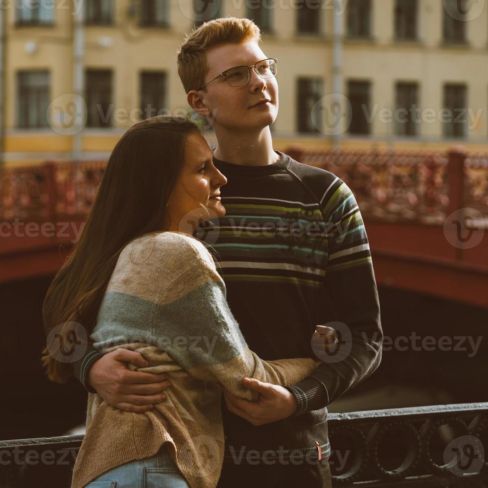 mann und frau stehen auf einer brücke mitten in der stadt und blicken in eine richtung nach oben. Junge und Mädchen träumen und denken. das Konzept der Jugendliebe, die erste ernsthafte Beziehung foto