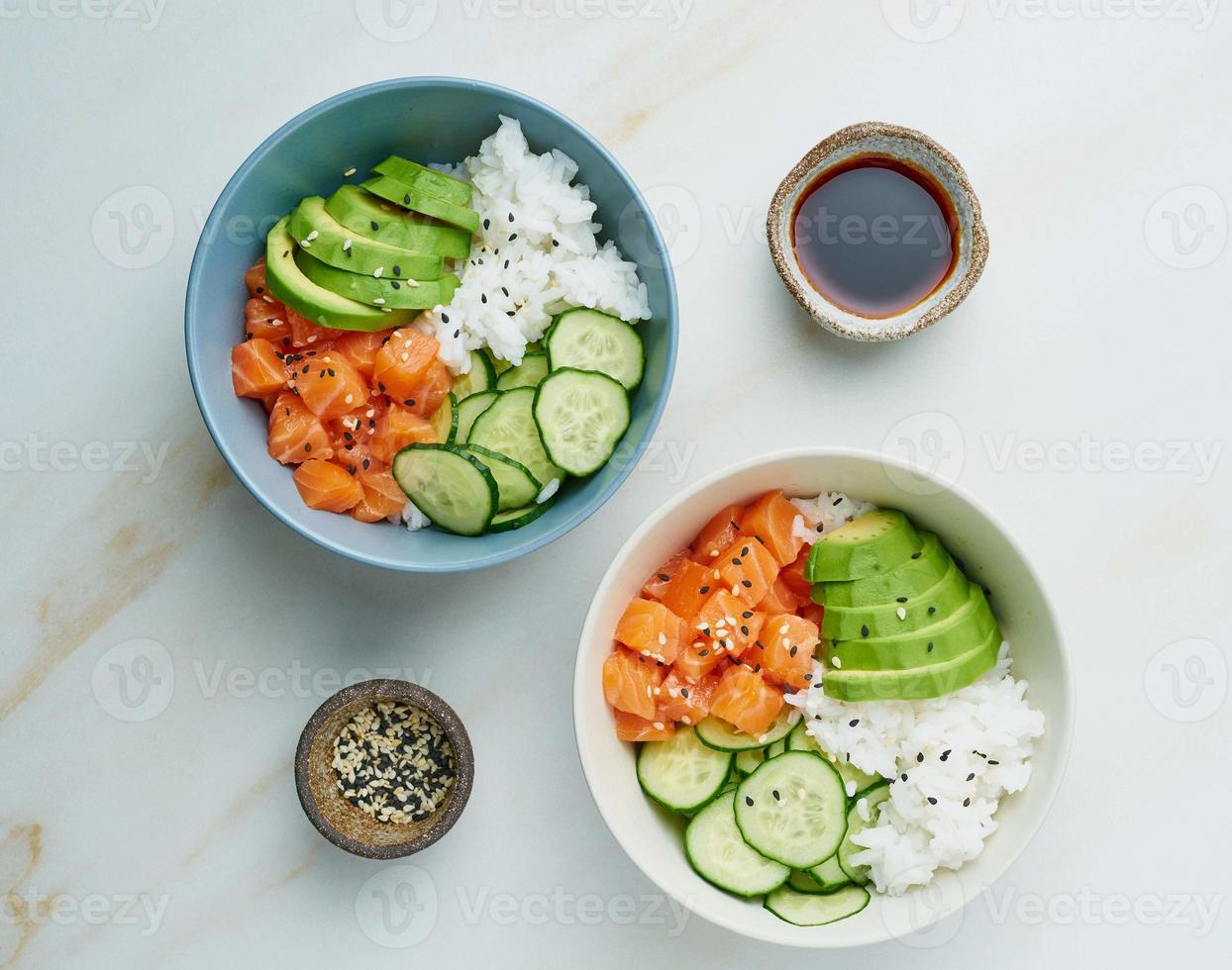 Lachs-Poke-Bowl mit frischem Fisch, Reis, Gurke, Avocado foto