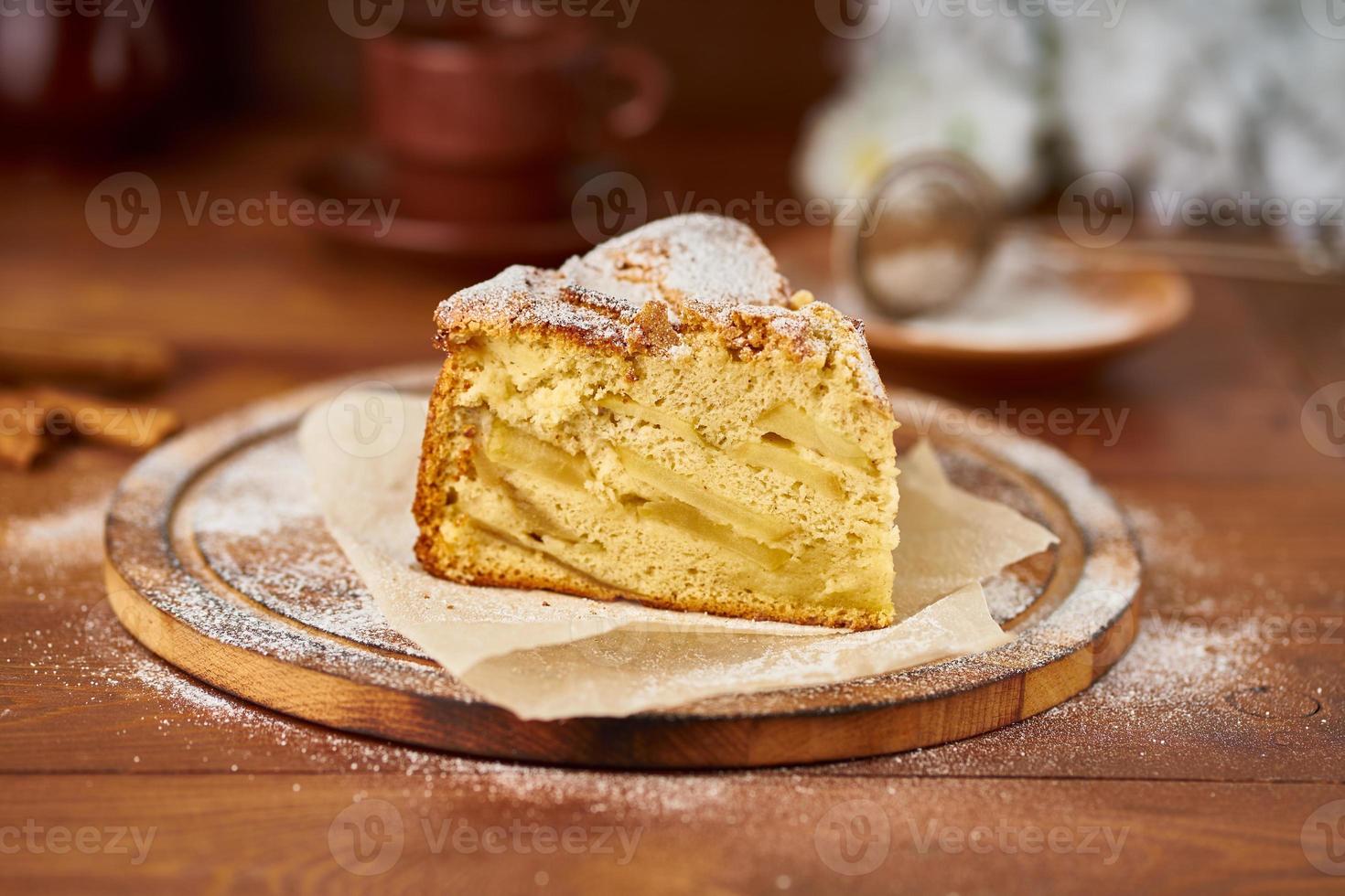 Stück Apfel französischer Kuchen mit Äpfeln, Zimt auf dunklem Küchentisch aus Holz, Seitenansicht foto