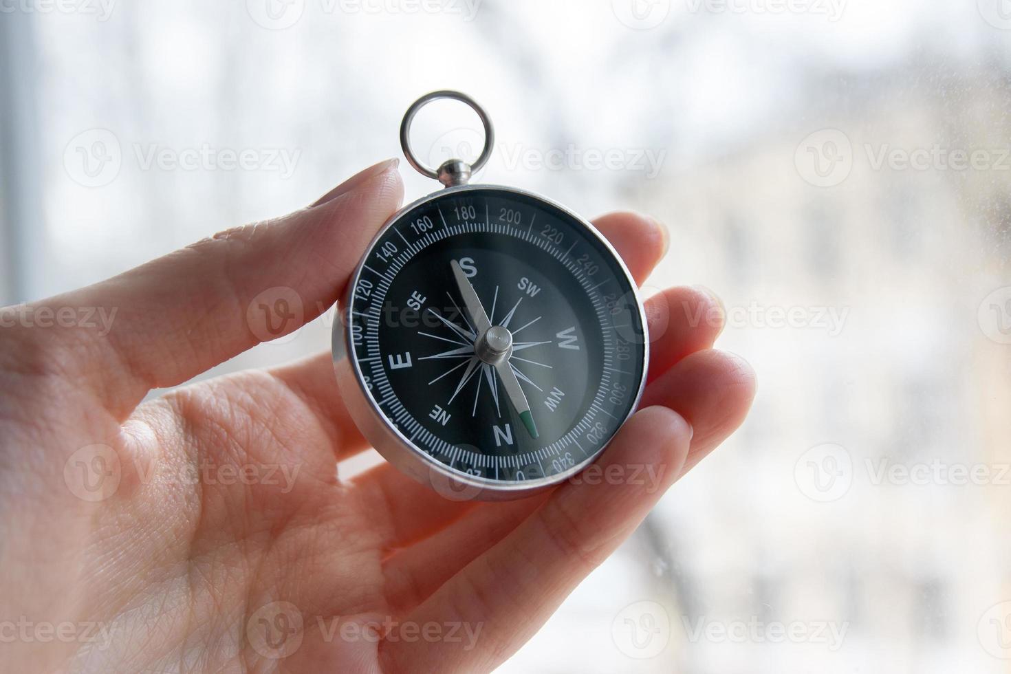schwarzer Kompass in einer weiblichen Hand foto