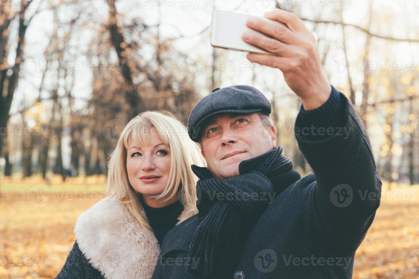 glückliche blonde reife Frau und hübscher brünetter Mann mittleren Alters foto